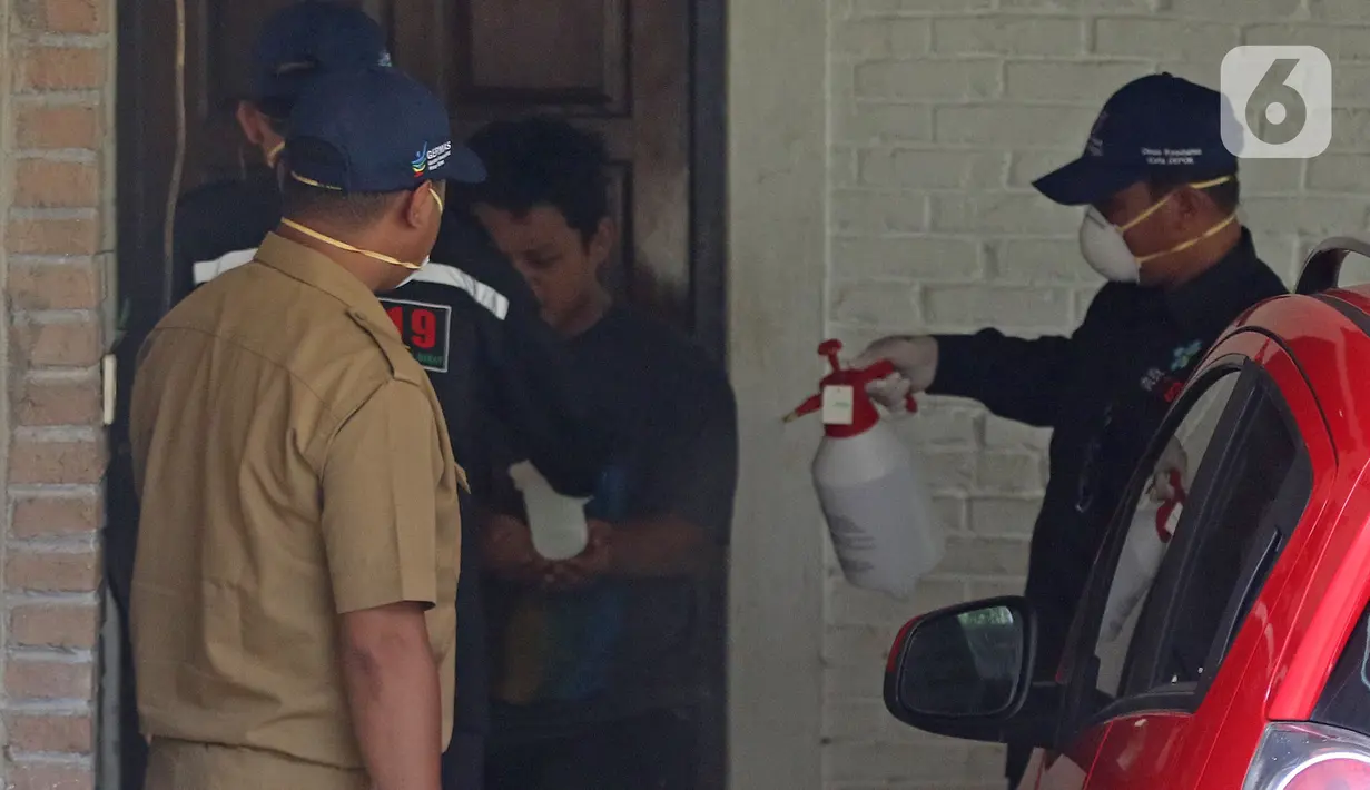 Petugas Dinkes Kota Depok melakukan sterilisasi dan evakuasi pekerja dirumah terjangkit virus corona  yang masih bertahan dirumah di Depok, Jawa Barat, Senin (2/3/2020). Dinkes Depok mengevakuasi pekerja untuk dibawa ke RSPI Sulyanti Saroso guna dilakukan pengecekan. (Liputan6.com/Herman Zakharia)