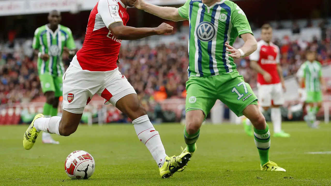 Winger Arsenal, Theo Walcott berduel dengan pemain Wolfsburg (Reuters)