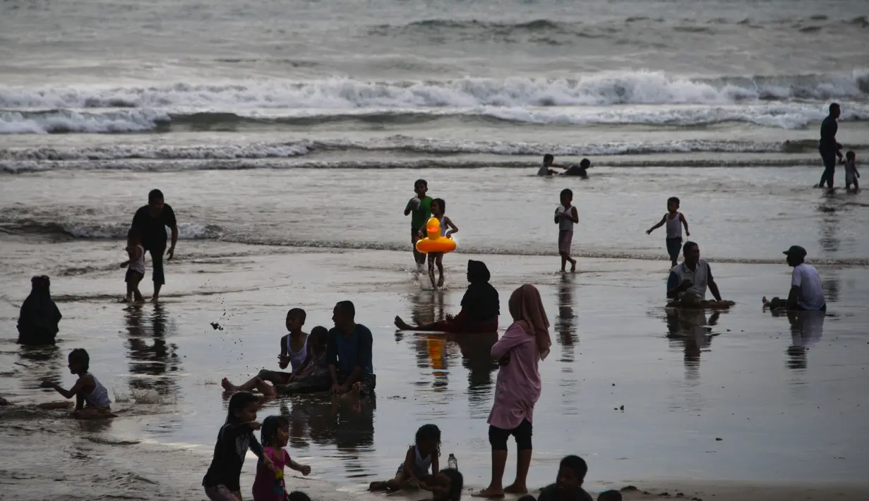 Suasana saat para wisatawan berlibur Lebaran di Pantai Lhoknga, Aceh Besar, Aceh, Minggu (9/6/2019). (CHAIDEER MAHYUDDIN/AFP)