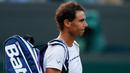 Petenis Spanyol, Rafael Nadal, saat akan meninggalkan lapangan setelah dikalahkan petenis Luksemburg, Giller Muller di perempat final Wimbledon 2017, Senin (10/7). Nadal menyerah dari Mueller usai melewati pertarungan lima set. (Adrian DENNIS/AFP)