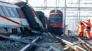 Petugas berdiri di samping kereta melihat kondisi dua kereta yang bertabrakan di Zurich, Swiss, (20/2/2015). Kereta bertabrakan di Swiss yang menyebabkan beberapa orang terluka dan rute komuter tergangu. (Reuters/ Arnd Wiegmann)