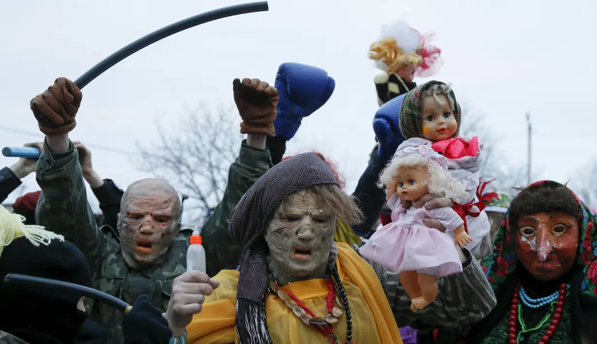 Warga mengenakan kostum seram saat melakukan perayaan hari libur Malanka di desa Krasnoyarsk, Chernivtsi, Ukraina, (14/1). Festival Malanka merupakan perayaan kaum pagan di Ukraina yang dirayakan setiap 13 Januari. (REUTERS/Valentyn Makarenko)