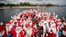 Sejumlah santa claus berlayar selama Kongres Dunia Sinterklas di Kopenhagen, Senin (23/7). Tahun ini 130 sinterklas dari berbagai penjuru dunia berkumpul di ibu kota Denmark untuk acara tiga hari tersebut. (Mads Claus Rasmussen/Scanpix via AP)