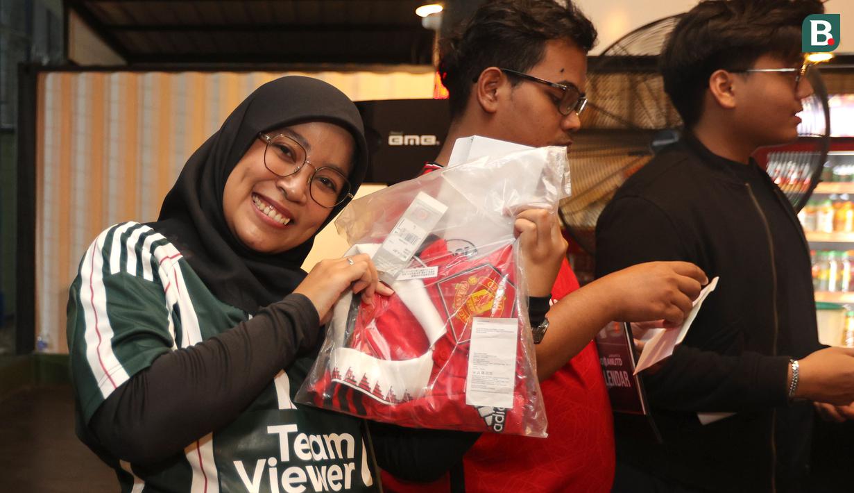 Salah satu orang dari komunitas IndoManUtd Regional Jakarta mendapatkan hadiah jersey original yang diberikan panitia dalam acara Roaring Night edisi perdana di Pitch 98, Kemang, Jakarta, Sabtu (23/12/2023). (Bola.com/Bagaskara Lazuardi)
