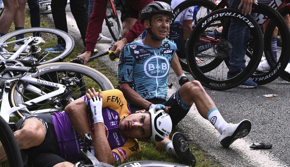 Kecelakaan disebabkan oleh suporter yang terlalu dekat dengan jalan dan tak menyadari dirinya terlalu dekat dengan peloton, sehingga pembalap Tim Jumbo-Visma, Tony Martin tak sengaja menabraknya dan mengawali kecelakaan massal. (Foto: AFP/Pool/Anne-Christine Poujoulat)