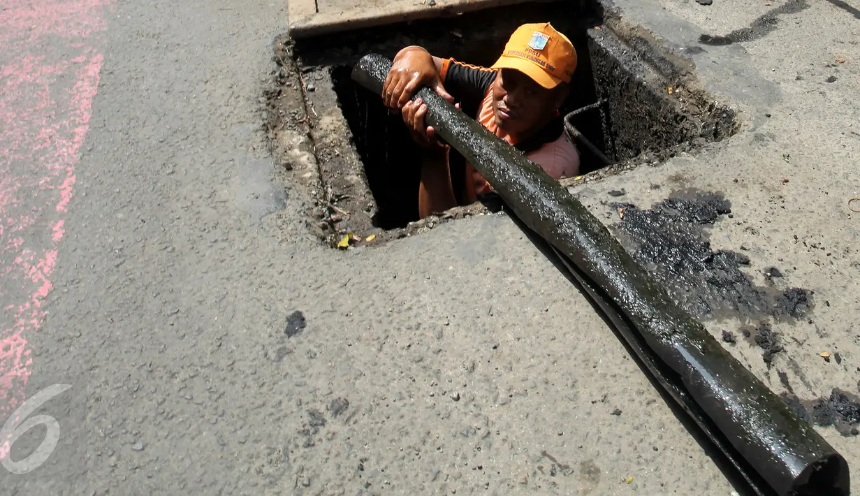 Petugas PPSU menemukan kulit kabel di gorong-gorong saluran air Jalan Gatot Subroto, Jakarta Selatan, Senin (6/3). Kulit kabel ini dianggap menjadi penyebab utama terjadinya banjir di Jalan Gatot Subroto pada 2 Maret 2017 lalu. (Liputan6.com/Johan Tallo)