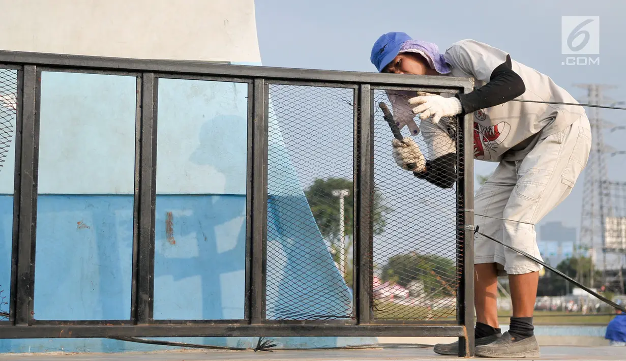 Pekerja mencopoti kawat pagar di arena skate di RPTRA Kalijodo, Jakarta, Selasa (6/6). Untuk menjaga kenyamanan saat bermain, arena skatepark RPTRA kalijodo yang rusak diperbaiki. (Liputan6.com/Yoppy Renato)