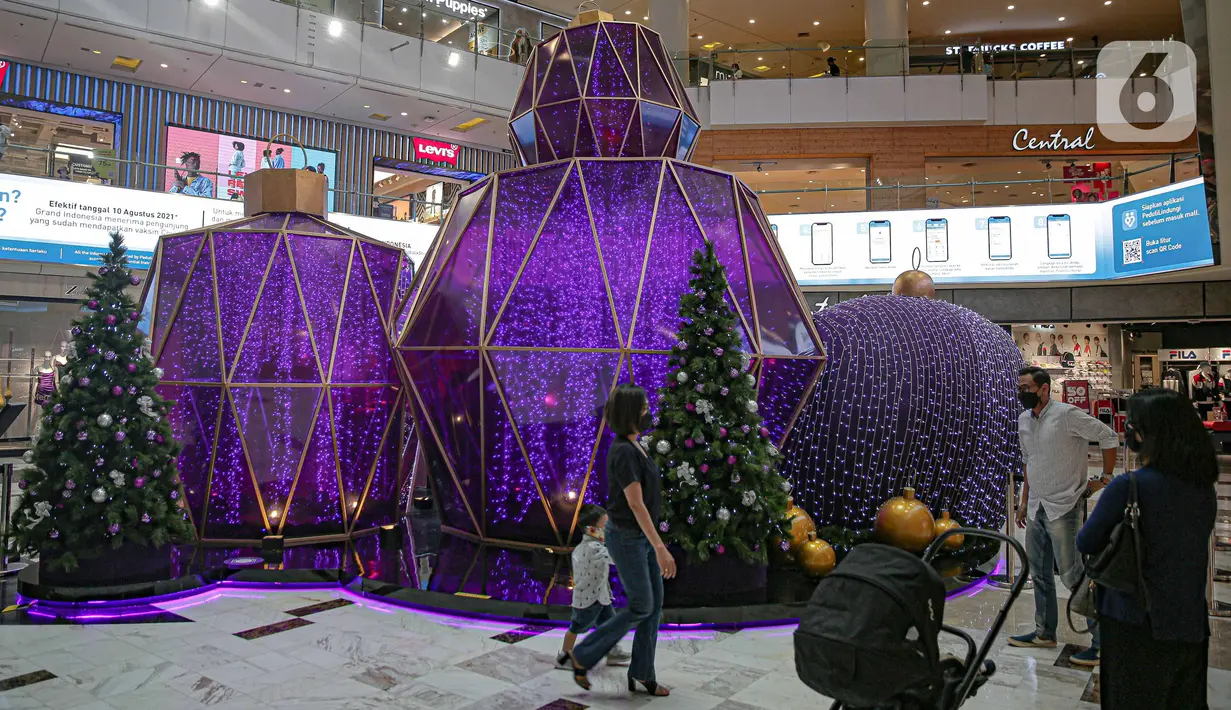 Pengunjung berada di dekat dekorasi perayaan Natal bertema "A Shining Shimmering Christmas" di Mal Grand Indonesia, Jakarta, Senin (13/12/2021). Pengunjung dapat menikmati kemegahan dan kehangatan Natal melalui dekorasi “infinity dome” yang berkilauan indah dan elegan. (Liputan6.com/Faizal Fanani)