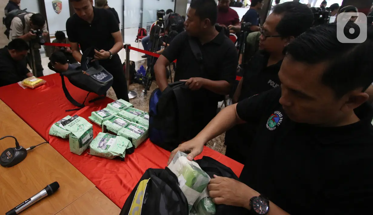 Petugas menata barang bukti saat rilis pengungkapan peredaran narkotika jenis sabu di Bareskrim Polri, Jakarta, Rabu (12/2/2020). Dirtidpid Narkoba Polri mengungkap sindikat narkotika jaringan Malaysia-Indonesia dengan barang bukti sabu 59 kg dan 20 butir pil ekstasi. (Liputan6.com/Angga Yuniar)