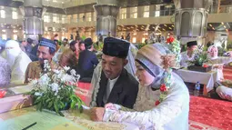 Program ini bertujuan untuk memfasilitasi pasangan, terutama mereka yang telah menikah secara agama namun belum sah secara hukum negara. Isbat ini agar pernikahan mereka tercatat resmi di Kantor Urusan Agama (KUA). Tampak dalam foto, pasangan pengantin mengikuti Isbat nikah massal 2025 di Mesjid Istiqlal, Jakarta, Rabu (3/12/2025). (merdeka.com/Arie Basuki)