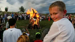 Warga berkumpul membentuk lingkaran sambil menari dan bernyanyi di sekitar api unggun saat perayaan Ivan Kupala di Kiev, Ukraina, Rabu (6/7). Mereka percaya akan kembali suci dengan mengikuti perayaan tersebut. (REUTERS/ Gleb Garanich)