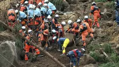 Petugas penyelamat dan polisi berusaha mencari korban usai terjadi longsor yang menghantam rumah hunian di Nakatsu, Prefektur Oita, Jepang (11/4). Sedikitnya enam orang hilang setelah tertimbun longsor. (AFP Photo/Jiji Press/Japan Out)