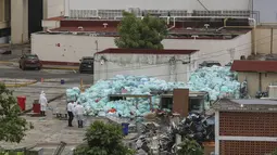 Petugas medis mengenakan alat pelindung diri saat membuang limbah biologis berbahaya di luar Rumah Sakit del Instituto Mexicano del Seguro Social, Veracruz, Meksiko, Rabu (12/8/2020). Pembuangan limbah medis yang tidak tepat menjadi masalah di tengah pandemi COVID-19. (AP Photo/Felix Marquez)