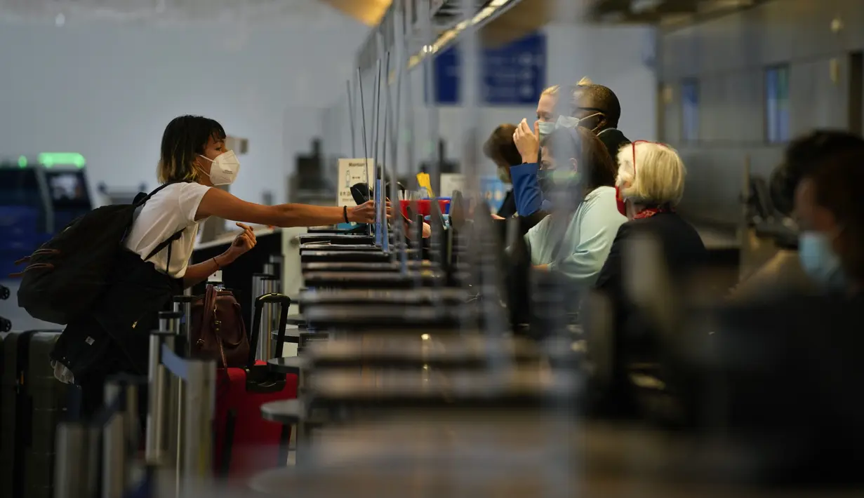 Seorang perempuan melakukan check in di Bandara Internasional Los Angeles di Los Angeles, California, 23 November 2020. Sekitar 1 juta orang Amerika memadati bandara dan pesawat menjelang libur Thanksgiving pekan ini bahkan saat kematian akibat COVID-19 melonjak. (AP Photo/Jae C. Hong)