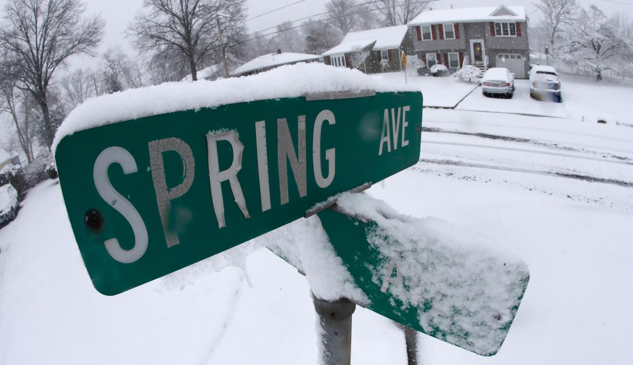 Salju menyelimuti plang nama jalan usai terjadi badai salju di Plainfield Manville, New Jersey (21/3). Salju tebal yang menutup jalanan ini berpotensi membahayakan warganya. (AP/Julio Cortez)