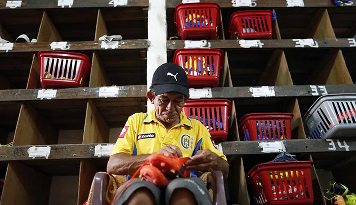 Juan Abalos membantu menyiapkan perlengkapan tim sebelum bertanding. (AP Photo/Jorge Saenz)
