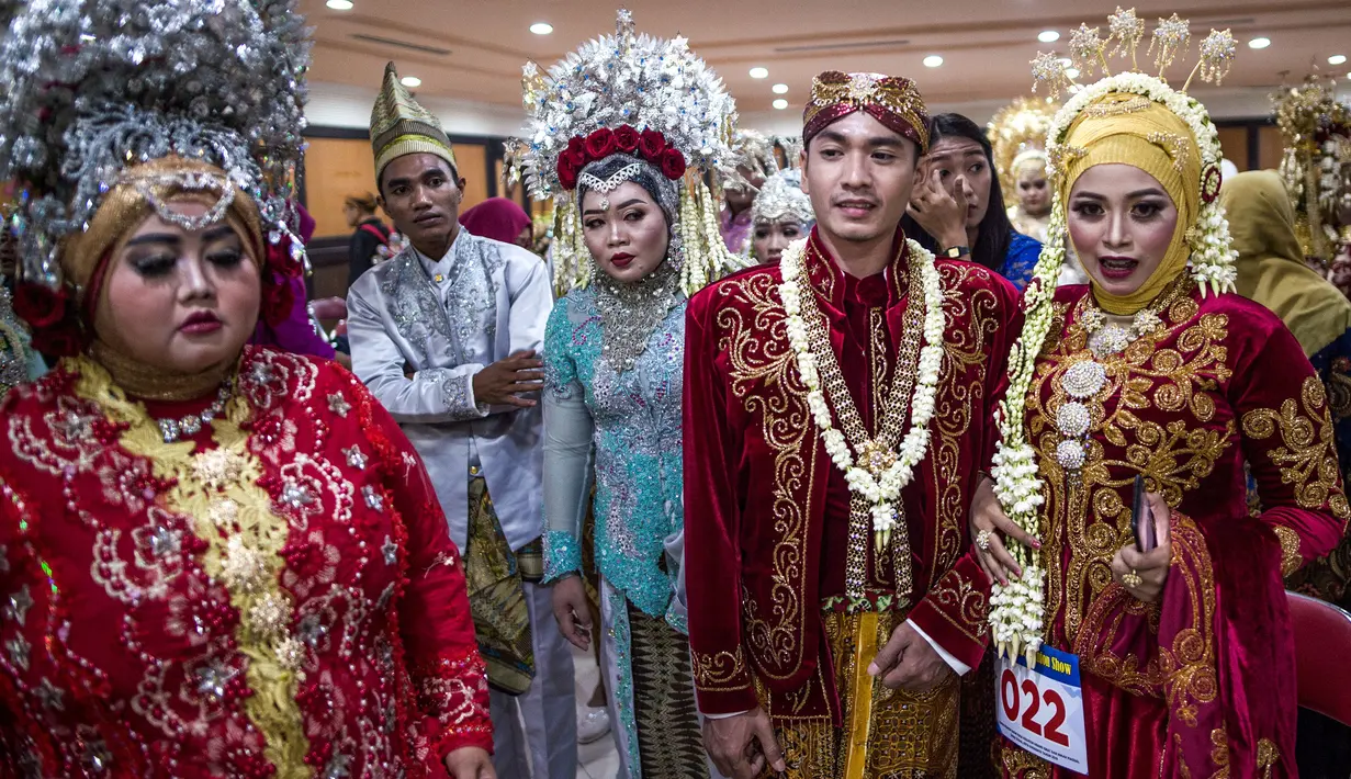 Sejumlah pasangan pengantin saat mengikuti nikah massal di Surabaya, Jawa Timur, Rabu (18/12/2019). Sebanyak 60 pasangan pengantin mengikuti nikah massal yang digelar Dinas Sosial Kota Surabaya. (JUNI KRISWANTO/AFP)