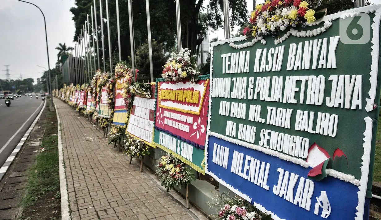 Pengendara melintasi deretan karangan bunga yang dipajang di depan Markas Kodam Jaya, Jakarta, Senin (23/11/2020). Ratusan karangan bunga dikirim masyarakat sebagai bentuk dukungan terhadap TNI dan Polri atas tindakan tegas kepada pelanggar protokol kesehtan Covid-19. (merdeka.com/Iqbal S Nugroho)