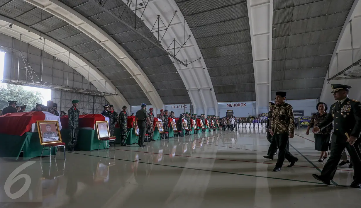 Presiden Joko Widodo (tengah) hadir dalam acara persemayaman di Hanggar Skadron Udara 17 Lanud Halim Perdanakusuma, Jakarta, (22/3). Helikopter TNI AD jenis Bell 412 EP dengan nomor HA 5171 jatuh pada minggu (20/3). (Liputan6.com/Faizal Fanani)