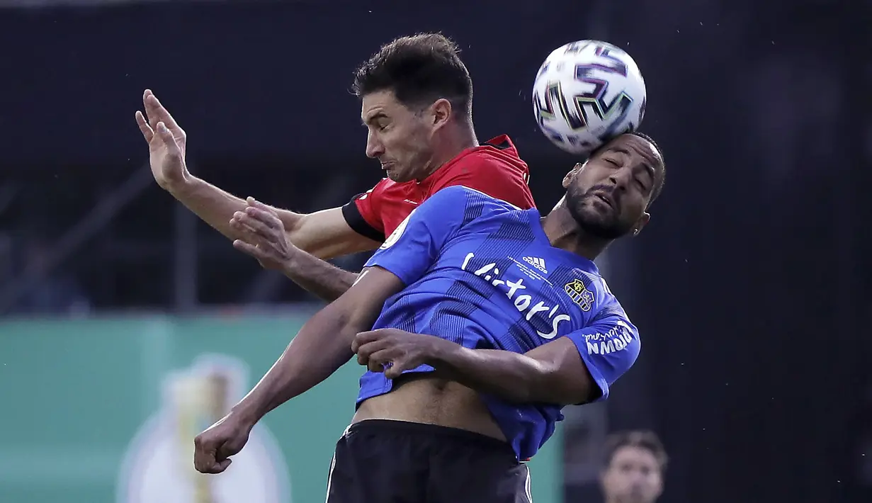 Pemain Bayer Leverkusen, Lucas Alario, duel udara dengan pemain FC Saarbruecken, Bone Uaferro,  pada laga Piala Jerman di di Stadion Hermann Neuberger, Voelklingen, Selasa (9/6/2020). Bayer Leverkusen menang 3-0 atas FC Saarbruecken. (AP/Ronald Wittek)