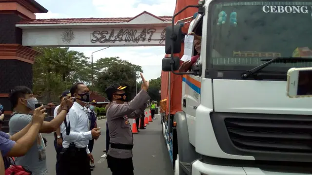 Petugas Kepolisian Resor Purbalingga meminta Sukron, seorang sopir truk, menunjukkan surat keterangan bebas Covid-19 saat operasi yustisi dalam rangka PPKM di perbatasan Banyumas-Purbalingga, Senin (11/1/2021).