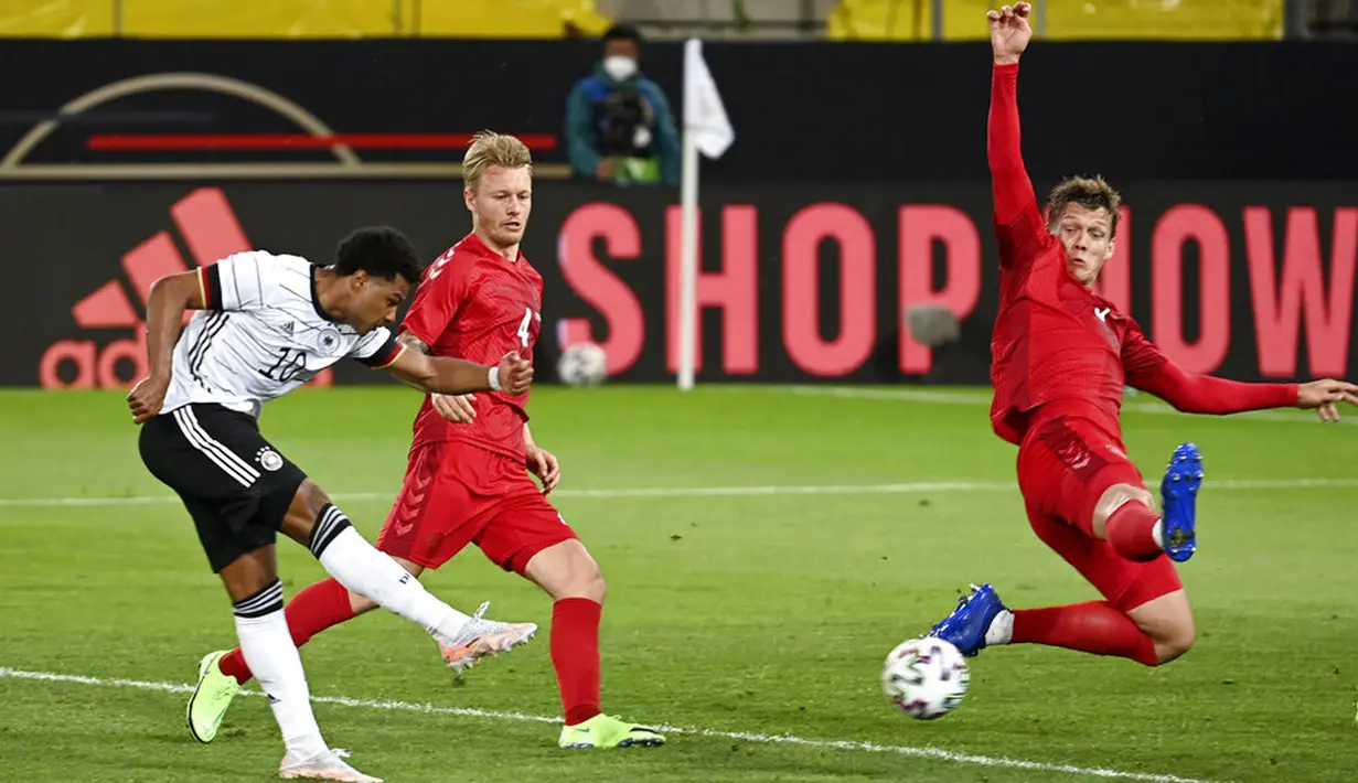 Pemain Jerman Serge Gnabry (kiri) mencoba melepaskan tembakan ke gawang Denmark pada pertandingan persahabatan di Tivoli Stadion Tirol, Innsbruck, Austria, Rabu (2/6/2021). Pertandingan berakhir dengan skor 1-1. (Frederico Gambarini/Pool via AP)