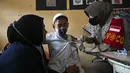 Seorang siswa menerima vaksin virus corona COVID-19 Sinovac di sebuah sekolah dasar di Darul Imarah, Kabupaten Aceh Besar, Provinsi Aceh, 14 Januari 2022. (CHAIDEER MAHYUDDIN/AFP)