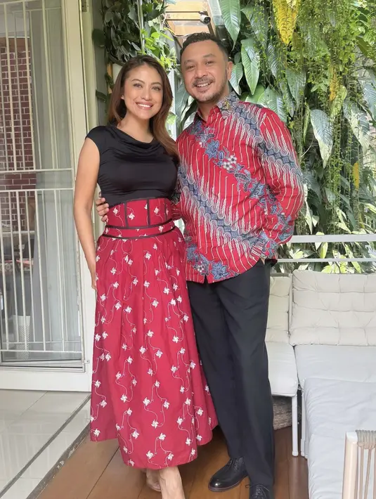 Menyelaraskan batik yang dipakai Giring, Cynthia kenakan dress merah dengan aksen korset.  [Foto: Instagram/ Cynthia Ganesha]