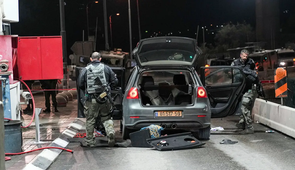 Pasukan keamanan Israel memeriksa lokasi serangan penikaman di pos pemeriksaan Mazmuria antara Yerusalem dan Tepi Barat, Kamis (28/12/2023). (AP Photo/Mahmoud Illean)
