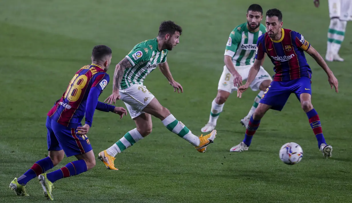 Penyerang Real Betis, Borja Iglesias menembak bola dari kawalan bek Barcelona, Jordi Alba pada pertandingan lanjutan La Liga Spanyol di stadion Benito Villamarin di Seville, Spanyol, Senin (8/2/2021). Barcelona menang tipis atas Real Betis 3-2. (AP Photo/Miguel Morenatti)