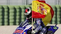 Jorge Lorenzo merayakan kemenangannya dengan membawa bendera Spanyol dalam MotoGP Valencia di Sirkuit Ricardo Tormo, Valencia, Spanyol, (8/11/2015). (EPA/Manuel Bruque)