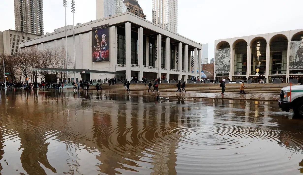 Banjir menggenangi jalanan dekat Lincoln Center for the Performing Arts di New York, Amerika Serikat, Senin (13/1/2020). Banjir diakibatkan rusaknya saluran air utama yang berdiameter tiga kaki. (AP Photo/Richard Drew)