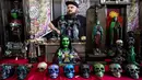 Seorang pria menjual patung di sebuah stan Paris Tattoo Convention di Grand Halle de la Villette, Paris, Prancis, Jumat (9/3). Paris Tattoo Convention tahun ini merupakan yang kedelapan. (Philippe LOPEZ/AFP)