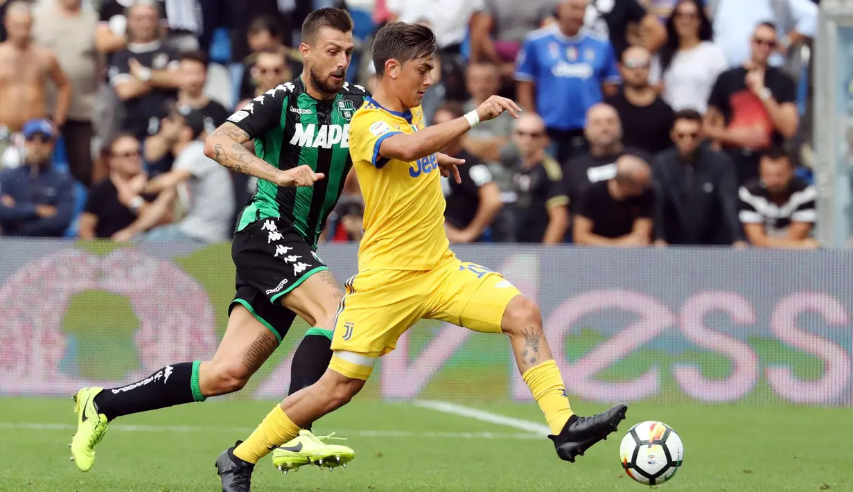 Aksi pemain Juventus, Paulo Dybala (kanan) melewati adangan pemain Sassuolo pada lanjutan Serie A di  Stadio Citta del Tricolore, Reggio Emilia, Italia (17/9/2017). Juventus menang 3-1.  (Elisabetta Baracchi/ANSA via AP)