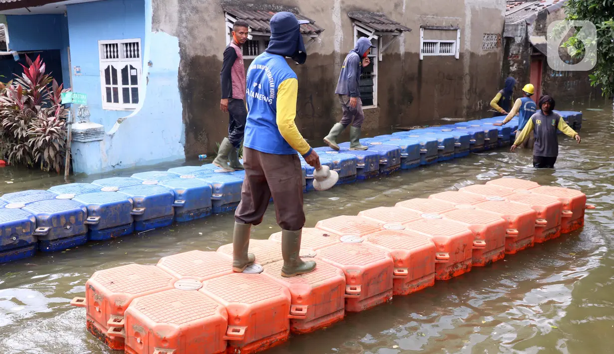 Petugas membuat jembatan apung saat banjir melanda Perumahan Periuk Damai, Tangerang, Banten, Selasa (23/2/2021). Adanya jembatan apung mempermudah warga saat melintasi banjir setinggi 2,5 meter di tempat tersebut. (Liputan6.com/Angga Yuniar)