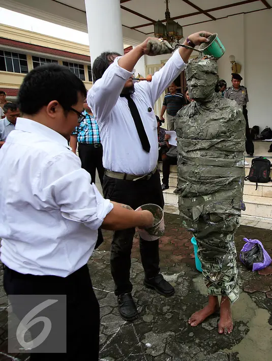 Seorang pengunjukrasa dari Aliansi Masyarakat Peduli Tata Ruang Yogyakarta megelar aksi teatrikal  manusia semen di Gedung DPRD DIY, (29/2). Mereka menuntut keseimbangan dalam fungsi dan kepemilikan ruang dengan masyarakat. (Liputan6.com/Boy Harjanto)