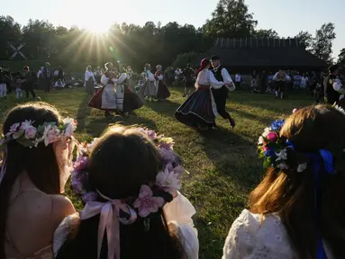 Orang-orang mengenakan pakaian tradisional menari selama perayaan Midsummer Day di Open Air Museum di Tallinn, Estonia, Jumat, 23 Juni 2023. (AP Photo/Pavel Golovkin)