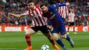 Pemain Athletic Bilbao Unai Nunez berusaha menghadang laju Lionel Messi saat pertandingan La Liga Spanyol di stadion Camp Nou di Barcelona (18/3). (AP Photo/Manu Fernandez)