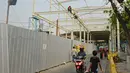 Warga melintas di antara proyek pembangunan "Skybridge" di Tanah Abang, Jakarta, Selasa (28/8). Pembangunan jembatan yang menghubungkan Stasiun Tanah Abang-Pasar Blok G Tanah Abang itu ditargetkan selesai pada Oktober 2018. (Liputan6.com/Herman Zakharia)