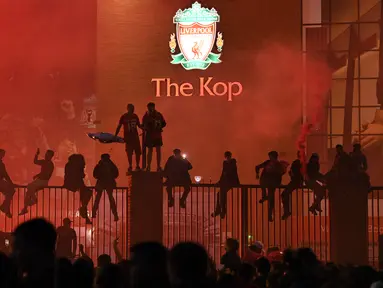 Fans Liverpool merayakan juara Premier League di area Standion Anfield usai pertandingan Liverpool melawan Chelsea, Kamis (23/7/2020) dini hari WIB. Fans Liverpool tetap berdatangan ke area Stadion Anfield meski ada permintaan untuk merayakan di rumah. (AFP/Oli Scarff)