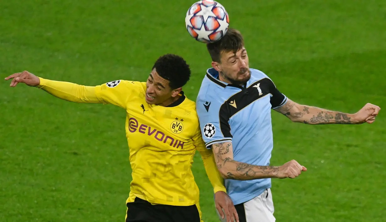 Gelandang Borussia Dortmund, Jude Bellingham (kiri) dan bek Lazio Francesco Acerbi bersaing memperebutkan bola pada matchday kelima Grup F Liga Champions di Signal Iduna Park, Dortmund, Kamis (3/12/2020) dinihari WIB. Borussia Dortmund cuma berimbang 1-1 dengan Lazio. (Bernd Thissen/POOL / AFP)