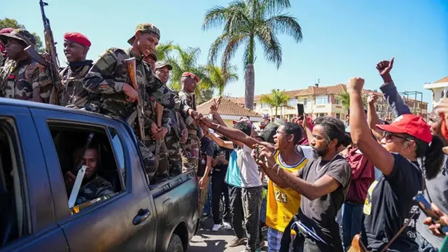 Tentara disambut oleh warga yang berkumpul dalam sebuah upacara untuk mengenang para demonstran yang tewas dalam aksi protes anti-pemerintah baru-baru ini di Antananarivo, Madagaskar, pada Minggu, (12/10/2025).