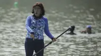 Menteri Kelautan dan Perikanan, Susi Pudjiastuti, menyapa penonton saat bermain paddle board di Danau Sunter, Jakarta, Minggu (25/2/2018). Kegiatan ini dilakukan dalam rangka Festival Danau Sunter. (Bola.com/Okie Prabhowo)