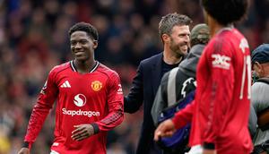 Pelatih interim Manchester United, Michael Carrick, meninggalkan lapangan bersama Kobbie Mainoo dari Manchester United di akhir pertandingan Liga Inggris antara Manchester United dan Liverpool di Manchester, Inggris, Minggu, 3 Mei 2026. (Foto AP/Dave Thompson)