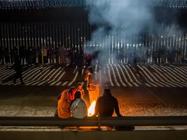 Migran bermalam di luar, di sepanjang pagar perbatasan AS-Meksiko sambil menunggu pengajuan suaka di Ciudad Juarez, Meksiko, Rabu (21/12/2022). Seharusnya pada tanggal 21 Desember 2022 AS resmi mencabut pembatasan pengungsi karena alasan pandemi Covid-19, namun Mahkamah Agung justru mengumumkan akan tetap membiarkan kebijakan Judul 42 tetap berlaku. (JOHN MOORE / GETTY IMAGES NORTH AMERICA / Getty Images via AFP)