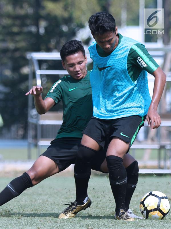 Pemain Timnas Indonesia U-19, Syahrian Abimanyu (kiri) berebut bola dengan rekannya saat latihan di Lapangan B Kompleks GBK, Jakarta, Selasa (18/9). Latihan ini persiapan  PSSI Anniversary Cup U-19 dan Piala AFC U19. (Liputan6.com/Helmi Fithriansyah)