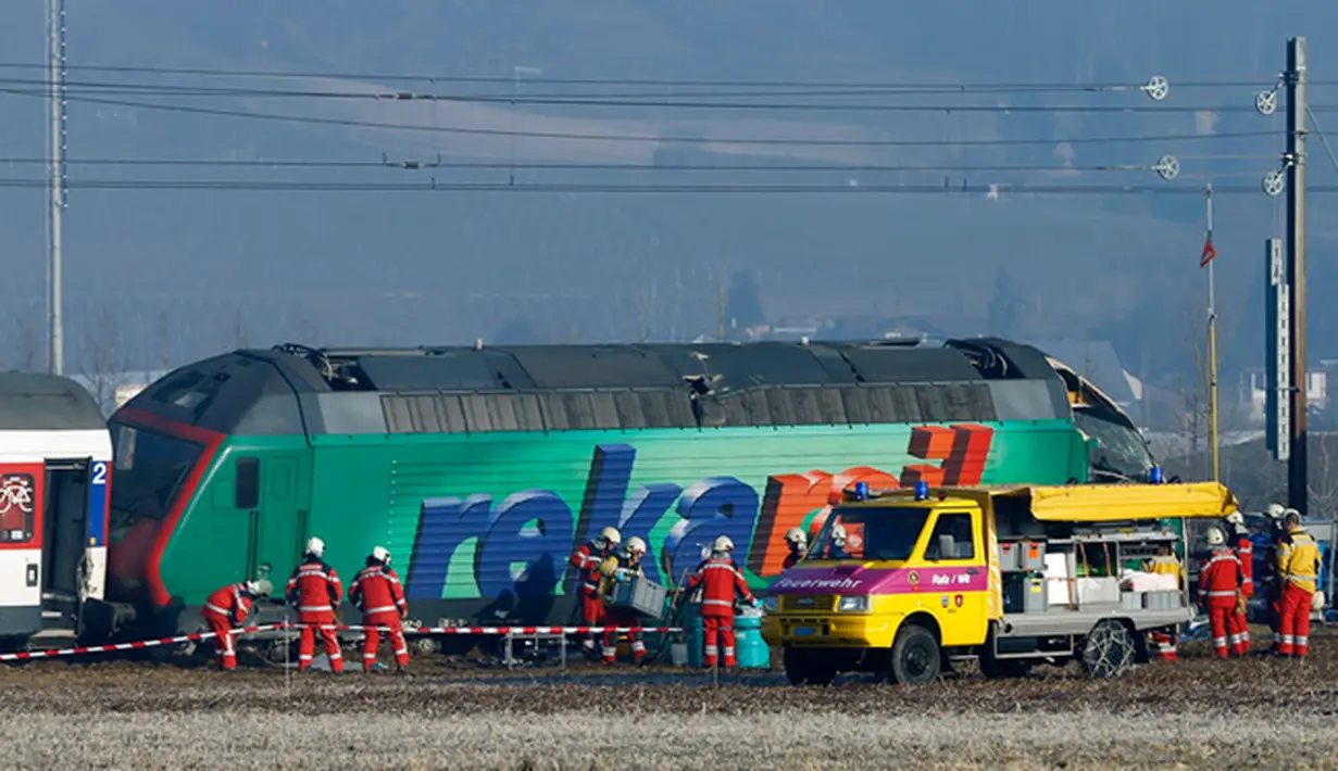 Petugas penyelamat berdiri di dekat dua kereta yang bertabrakan di Zurich, Swiss, (20/2/2015). Kereta bertabrakan di Swiss yang menyebabkan beberapa orang terluka dan rute komuter tergangu. (Reuters/ Arnd Wiegmann)