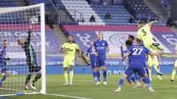 Bek Newcastle United, Paul Dummett (kanan) melepaskan sundulan yang berbuah gol kedua timnya ke gawang Leicester City dalam laga lanjutan Liga Inggris 2020/2021 pekan ke-35 di King Power Stadium, Leicester, Jumat (7/5/2021). Newcastle menang 4-2 atas Leicester. (AP/Alex Pantling/Pool)