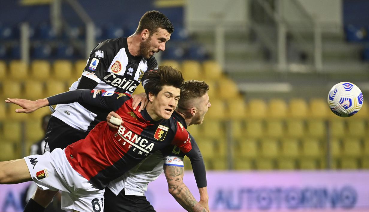 Striker Genoa, Eldor Shomurodov (depan) berebut bola dengan bek Parma, Mattia Bani (atas) dalam laga lanjutan Liga Italia 2020/2021 pekan ke-28 di Ennio Tardini Stadium, Parma, Jumat (19/3/2021). Genoa menang 2-1 atas Parma. (LaPresse via AP/Massimo Paolone)