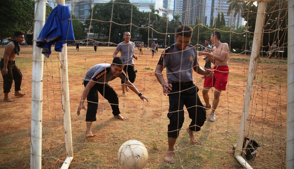 Polisi dari kesatuan Sabhara merenggangkan otot dengan bermain bola di Kawasan Polda Metro, Jakarta, Selasa (13/10/2015). Pihak Kepolisian dan TNI bersiap siaga menjelang laga Final Piala Presiden 2015. (Bola.com/Nicklas Hanoatubun).